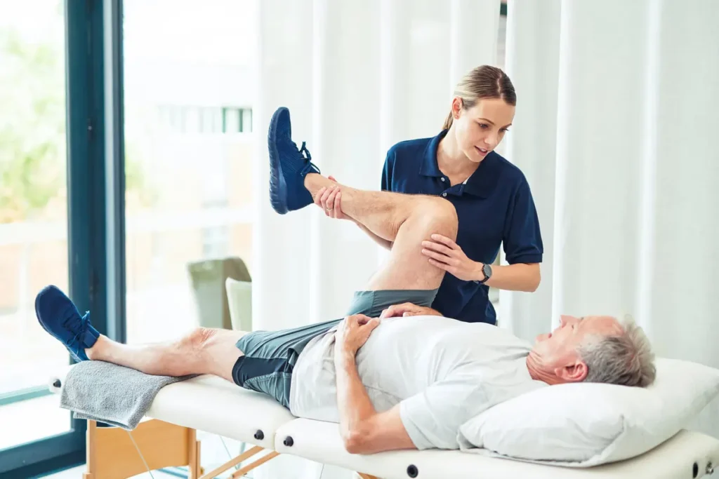 Physiotherapist assisting a patient with muscle recovery exercises Witley