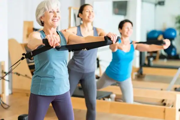 older woman doing weight training Witley and resistance in the gym to tone upper arms